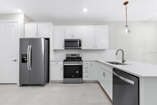 7661 Summerland Cv, Bradenton, FL 34202 - kitchen with appliances with stainless steel finishes, backsplash, white cabinets, a peninsula, and pendant lighting