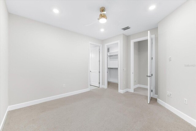 7661 Summerland Cv, Bradenton, FL 34202 - unfurnished bedroom with light colored carpet, recessed lighting, a walk in closet, ceiling fan, and a closet