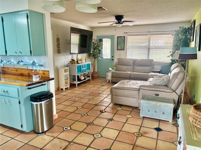 3767 Pinstar Ter, North Port, FL 34287 - living room with a ceiling fan, a textured ceiling, and light tile patterned flooring