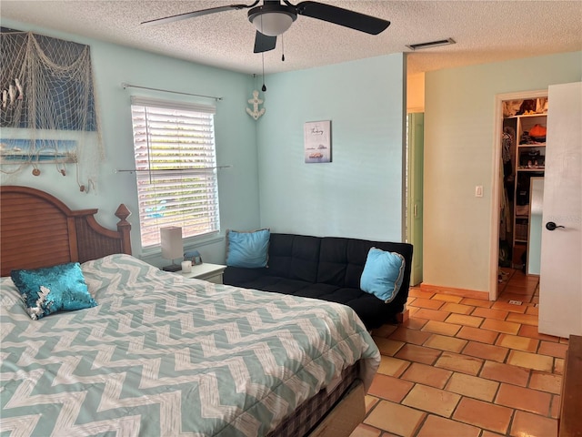 3767 Pinstar Ter, North Port, FL 34287 - bedroom with a textured ceiling, ceiling fan, and a walk in closet