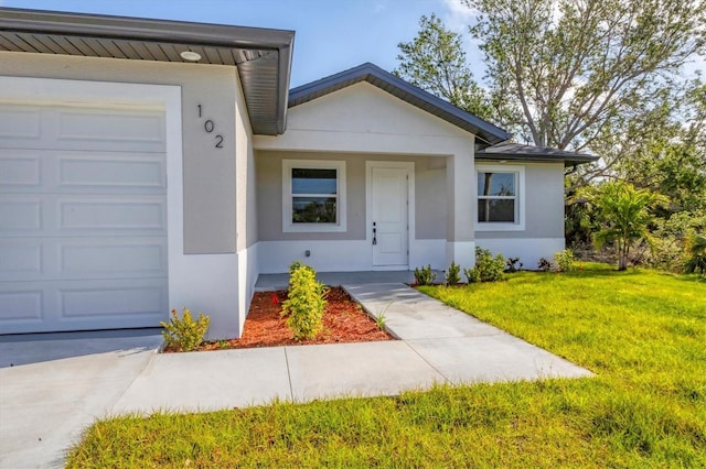 102 Arrow Ln, Rotonda West, FL 33947 - view of front of home with stucco siding, a front yard, and a garage