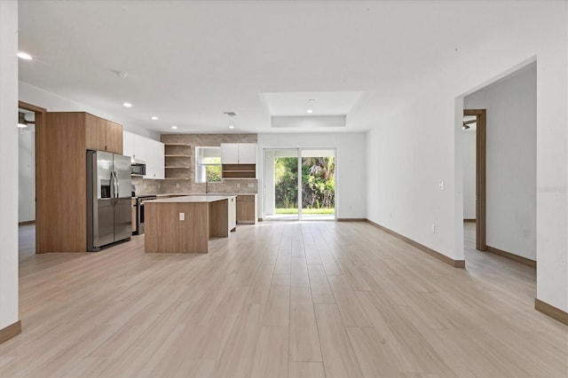 102 Arrow Ln, Rotonda West, FL 33947 - kitchen featuring stainless steel appliances, open shelves, a kitchen island, open floor plan, and tasteful backsplash