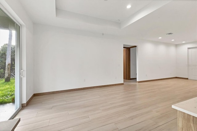 102 Arrow Ln, Rotonda West, FL 33947 - empty room with light wood finished floors, a raised ceiling, and recessed lighting
