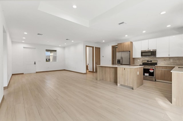 102 Arrow Ln, Rotonda West, FL 33947 - kitchen with stainless steel appliances, a kitchen island, modern cabinets, decorative backsplash, and recessed lighting