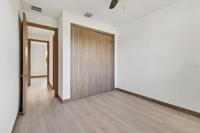 102 Arrow Ln, Rotonda West, FL 33947 - unfurnished bedroom with light wood-style floors, a closet, and ceiling fan