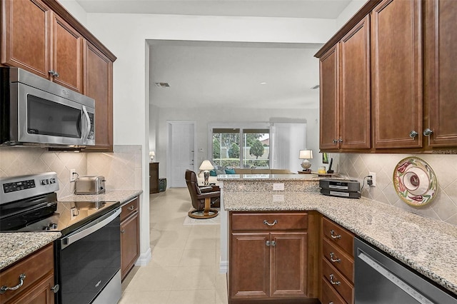 5662 Fossano Dr, Sarasota, FL 34238 - kitchen featuring stainless steel appliances, light stone counters, tasteful backsplash, and a peninsula