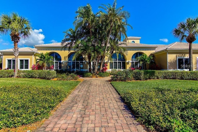 5662 Fossano Dr, Sarasota, FL 34238 - mediterranean / spanish home featuring stucco siding, a tile roof, and a front lawn