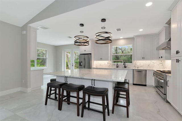 920 Lena Ln, Sarasota, FL 34240 - kitchen with appliances with stainless steel finishes, decorative backsplash, wall chimney range hood, healthy amount of natural light, and recessed lighting