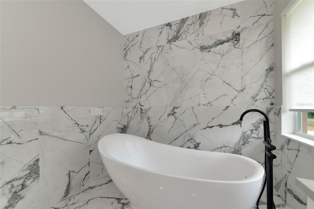 920 Lena Ln, Sarasota, FL 34240 - full bath featuring tile walls, stone wall, a freestanding bath, and marble tiled flooring