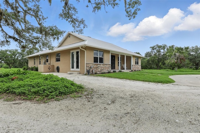 920 Lena Ln, Sarasota, FL 34240 - ranch-style house with stone siding, stucco siding, french doors, a front yard, and driveway