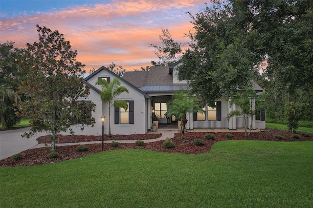 3906 Twin Rivers Trl, Parrish, FL 34219 - modern farmhouse style home with a lawn, covered porch, stucco siding, and a standing seam roof