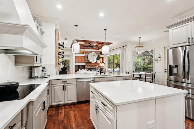 3906 Twin Rivers Trl, Parrish, FL 34219 - kitchen with appliances with stainless steel finishes, custom range hood, a peninsula, a center island, and recessed lighting