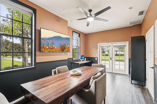 3906 Twin Rivers Trl, Parrish, FL 34219 - dining area featuring french doors, plenty of natural light, ceiling fan, wood finished floors, and a textured ceiling