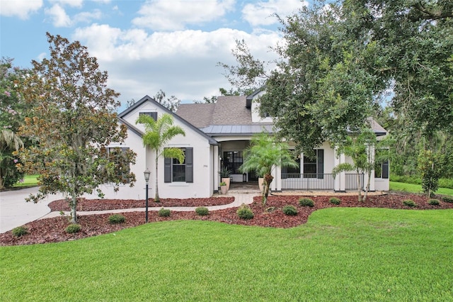 3906 Twin Rivers Trl, Parrish, FL 34219 - modern inspired farmhouse featuring covered porch, a front lawn, a standing seam roof, stucco siding, and a metal roof