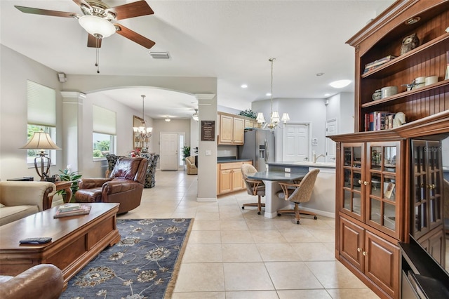 1415 Millbrook Cir, Bradenton, FL 34212 - living area with a chandelier, ornate columns, a ceiling fan, arched walkways, and light tile patterned floors