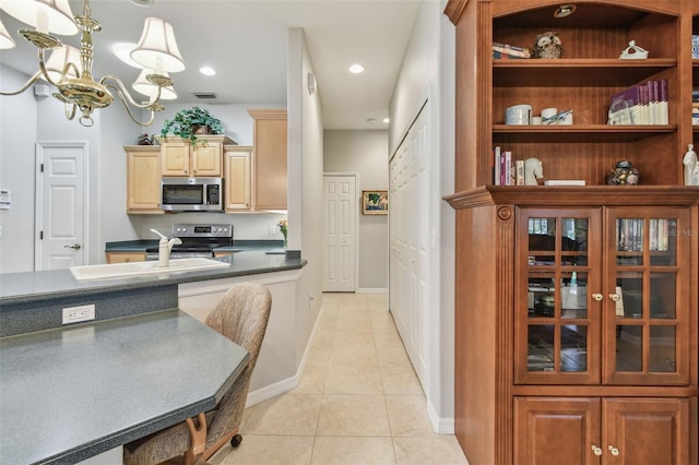 1415 Millbrook Cir, Bradenton, FL 34212 - kitchen with stainless steel appliances, light tile patterned flooring, dark countertops, a chandelier, and recessed lighting