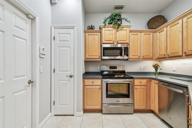 1415 Millbrook Cir, Bradenton, FL 34212 - kitchen with stainless steel appliances, light tile patterned flooring, and dark countertops