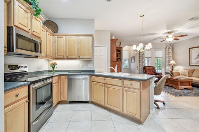 1415 Millbrook Cir, Bradenton, FL 34212 - kitchen featuring stainless steel appliances, a peninsula, light brown cabinets, dark countertops, and open floor plan