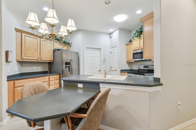 1415 Millbrook Cir, Bradenton, FL 34212 - kitchen with appliances with stainless steel finishes, light brown cabinetry, dark countertops, a peninsula, and recessed lighting
