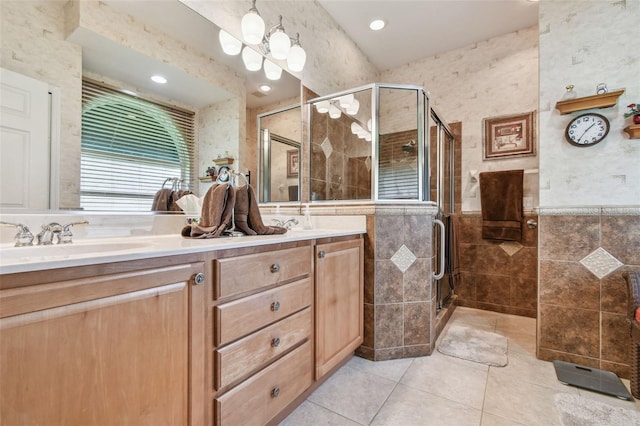1415 Millbrook Cir, Bradenton, FL 34212 - bathroom featuring tile walls, double vanity, a stall shower, tile patterned flooring, and a wainscoted wall
