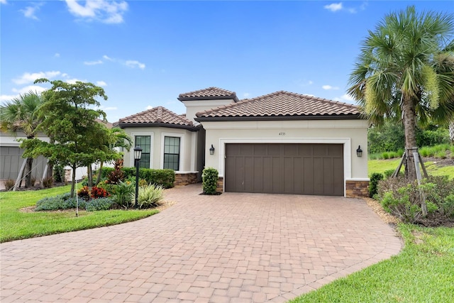 4735 Cassio Ct, Bradenton, FL 34211 - mediterranean / spanish-style house with stone siding, a garage, stucco siding, and decorative driveway