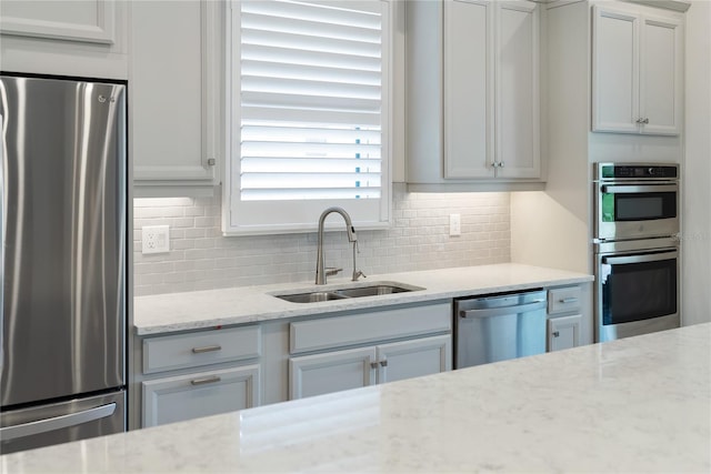 4735 Cassio Ct, Bradenton, FL 34211 - kitchen featuring appliances with stainless steel finishes, decorative backsplash, and light stone counters
