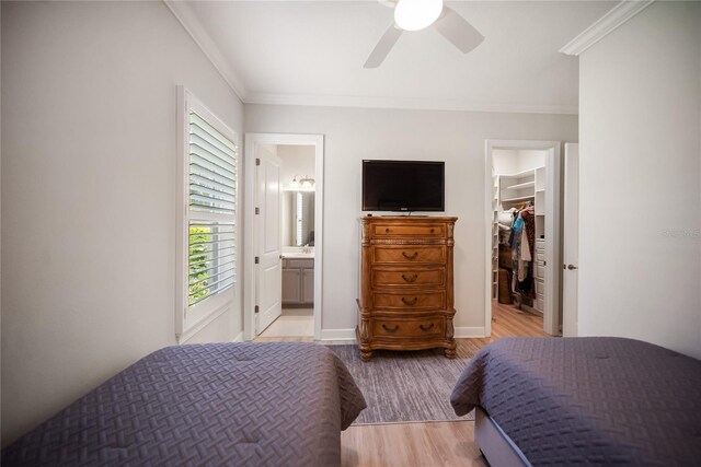 4735 Cassio Ct, Bradenton, FL 34211 - bedroom featuring a walk in closet, wood finished floors, crown molding, a closet, and ensuite bath
