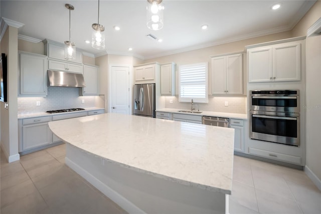 4735 Cassio Ct, Bradenton, FL 34211 - kitchen with appliances with stainless steel finishes, under cabinet range hood, tasteful backsplash, a center island, and light tile patterned floors