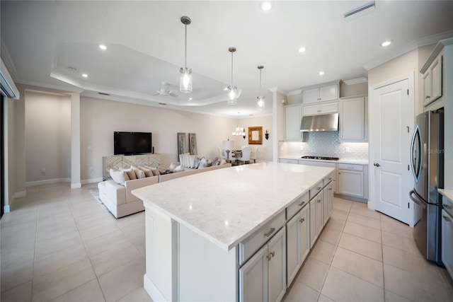 4735 Cassio Ct, Bradenton, FL 34211 - kitchen with freestanding refrigerator, under cabinet range hood, ornamental molding, gas cooktop, and tasteful backsplash