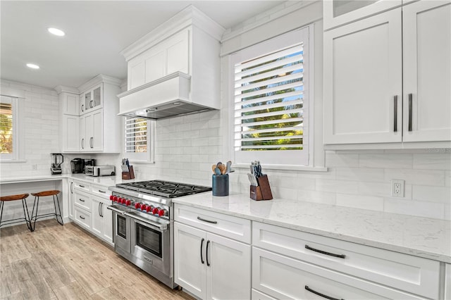 119 Avenida Messina, Sarasota, FL 34242 - kitchen with double oven range, tasteful backsplash, white cabinetry, recessed lighting, and glass insert cabinets