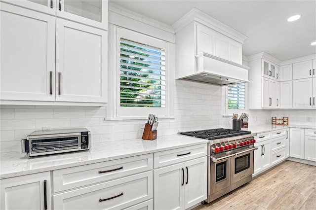 119 Avenida Messina, Sarasota, FL 34242 - kitchen featuring double oven range, white cabinets, recessed lighting, tasteful backsplash, and light wood finished floors