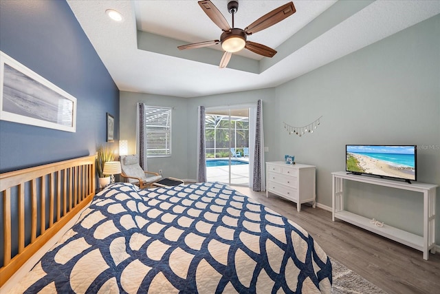 5619 Oak Grove Ct, Sarasota, FL 34233 - bedroom with access to outside, wood finished floors, a tray ceiling, and ceiling fan