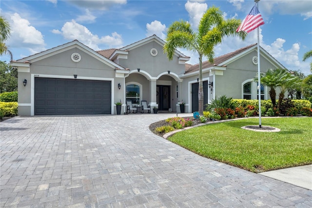 16038 39th Gln E, Parrish, FL 34219 - view of front of house featuring a garage, decorative driveway, stucco siding, and a front yard