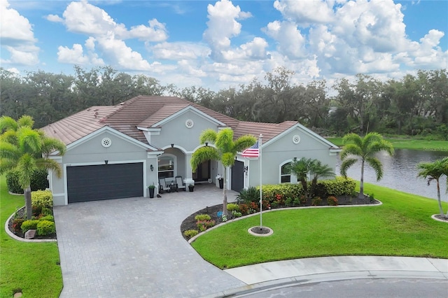 16038 39th Gln E, Parrish, FL 34219 - mediterranean / spanish-style house featuring an attached garage, decorative driveway, a tiled roof, and a front lawn