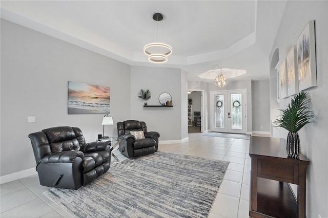 16038 39th Gln E, Parrish, FL 34219 - living room with light tile patterned floors, a tray ceiling, a chandelier, french doors, and arched walkways