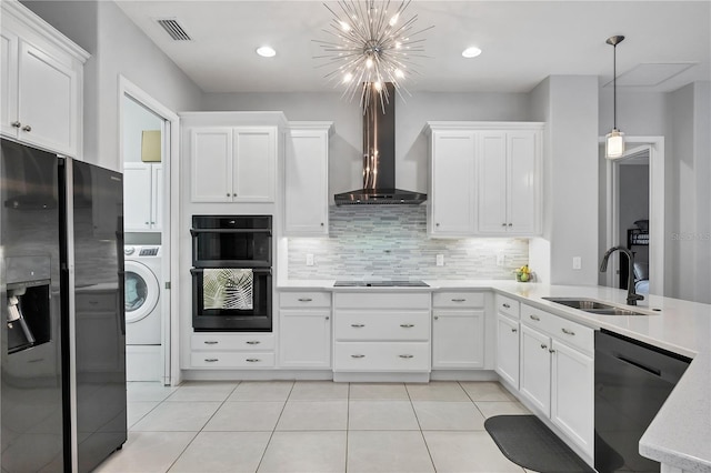 16038 39th Gln E, Parrish, FL 34219 - kitchen featuring black appliances, washer / dryer, wall chimney range hood, a chandelier, and white cabinets