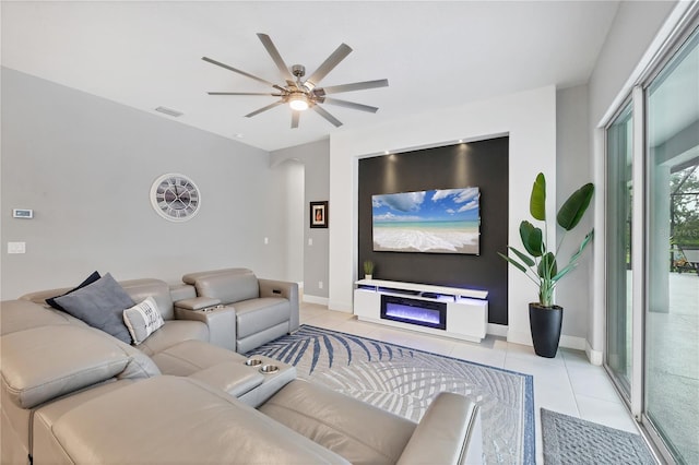 16038 39th Gln E, Parrish, FL 34219 - living room featuring light tile patterned floors, a ceiling fan, arched walkways, and a glass covered fireplace