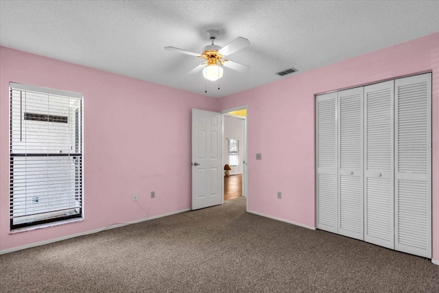 327 40th Ct W, Palmetto, FL 34221 - unfurnished bedroom featuring carpet, a textured ceiling, a closet, and a ceiling fan
