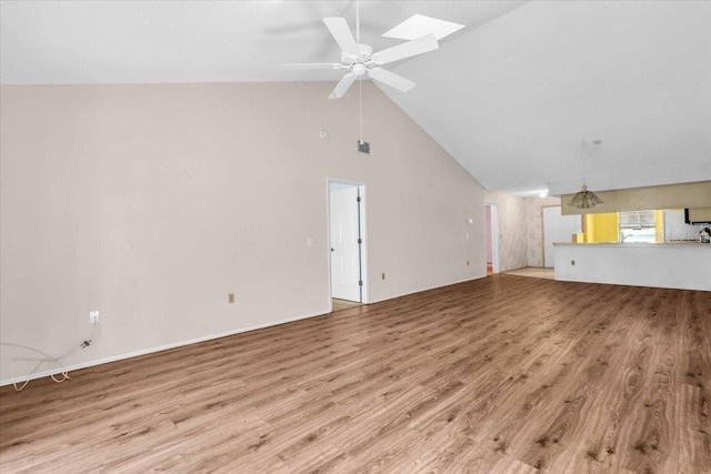 327 40th Ct W, Palmetto, FL 34221 - unfurnished living room featuring wood finished floors, lofted ceiling, ceiling fan, and a skylight