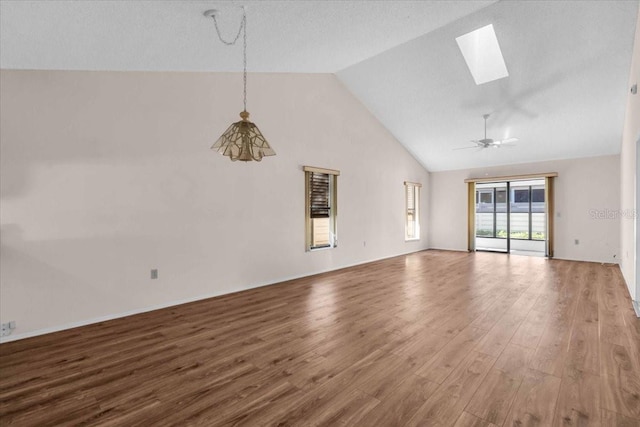 327 40th Ct W, Palmetto, FL 34221 - unfurnished living room with a skylight, wood finished floors, ceiling fan, and high vaulted ceiling