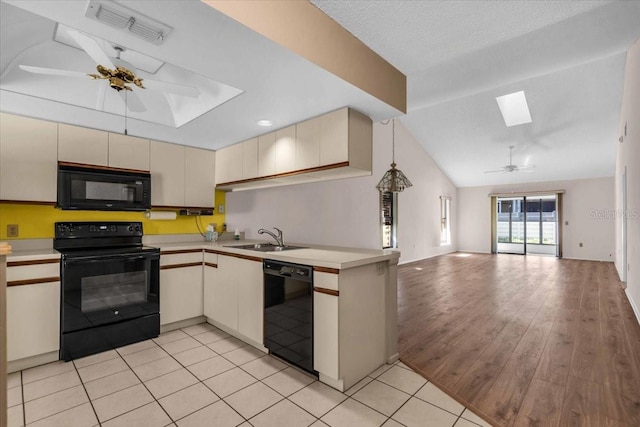 327 40th Ct W, Palmetto, FL 34221 - kitchen featuring black appliances, a skylight, cream cabinetry, ceiling fan, and open floor plan