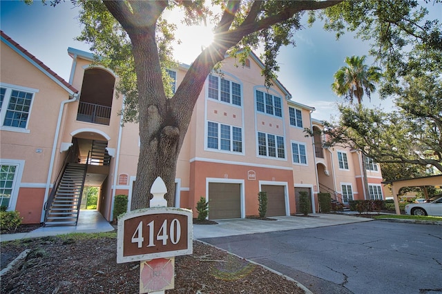 4140 Central Sarasota Pkwy Unit 1235, Sarasota, FL 34238 - view of property with stairway, concrete driveway, and a garage