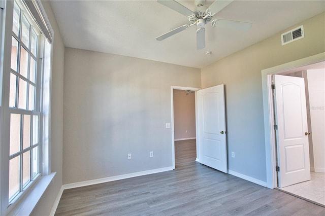 4140 Central Sarasota Pkwy Unit 1235, Sarasota, FL 34238 - unfurnished bedroom with multiple windows, wood finished floors, and ceiling fan