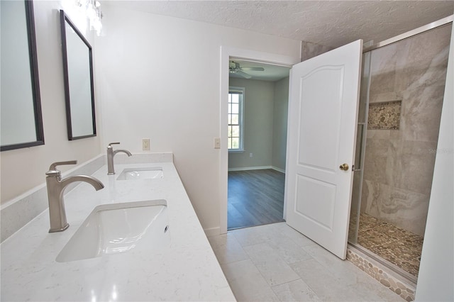 4140 Central Sarasota Pkwy Unit 1235, Sarasota, FL 34238 - full bathroom with a stall shower, ceiling fan, double vanity, and a textured ceiling
