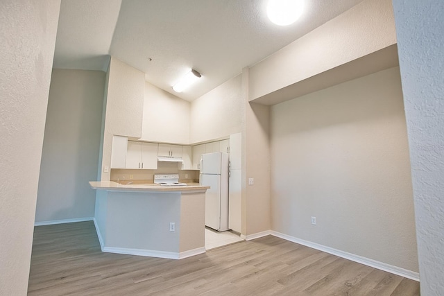 4140 Central Sarasota Pkwy Unit 1235, Sarasota, FL 34238 - kitchen featuring freestanding refrigerator, light wood-style flooring, range, a peninsula, and light countertops