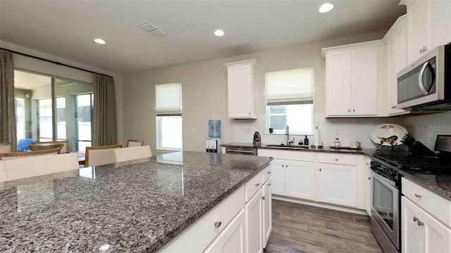 11223 Spring Gate Trl, Bradenton, FL 34211 - kitchen with stainless steel appliances, white cabinets, dark stone counters, and recessed lighting