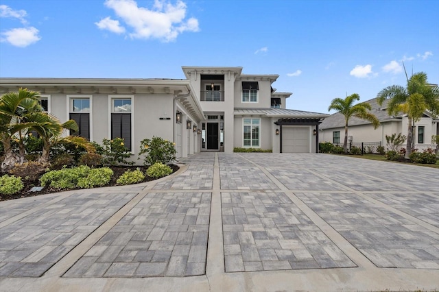 676 Regatta Way, Bradenton, FL 34208 - view of front facade with stucco siding, decorative driveway, a garage, and a standing seam roof