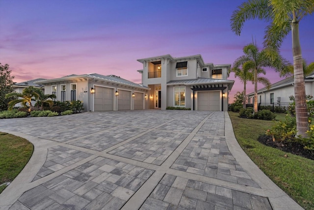 676 Regatta Way, Bradenton, FL 34208 - contemporary house with an attached garage, decorative driveway, stucco siding, a standing seam roof, and a metal roof