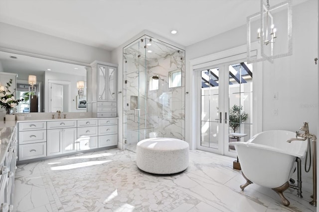 676 Regatta Way, Bradenton, FL 34208 - bathroom featuring marble tiled floors, a marble finish shower, a chandelier, french doors, and vanity