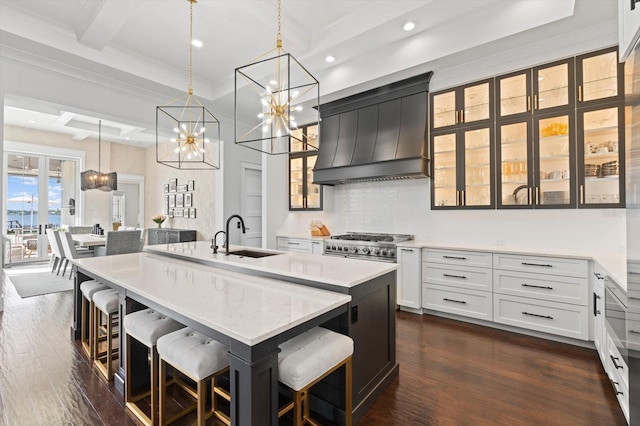 676 Regatta Way, Bradenton, FL 34208 - kitchen with custom exhaust hood, a chandelier, a center island with sink, dark wood-style flooring, and recessed lighting